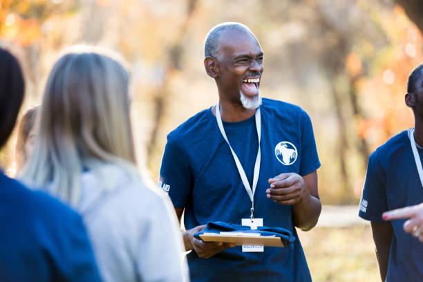 istock Happy volunteer coordinator gives instructions during community cleanup day 1199706318