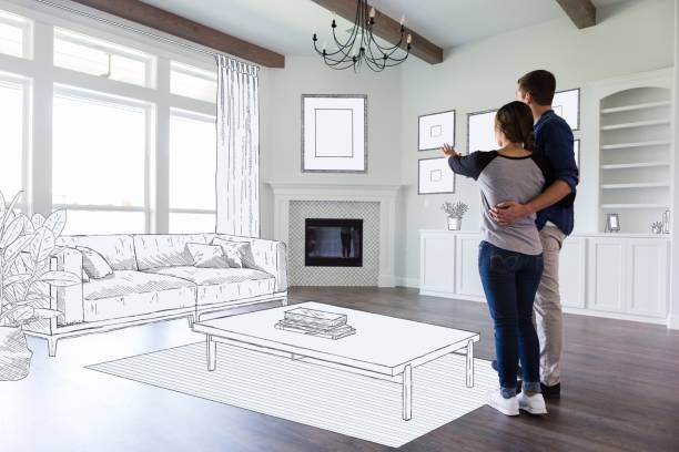 Couple dream in their new home A young couple stand in the empty living room of their new home and imagine the room decor and furniture placement. home showcase interior photos stock pictures, royalty-free photos & images