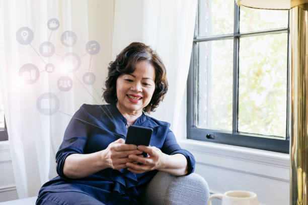 istock Senior woman uses smartphone while relaxing at home 1199708229