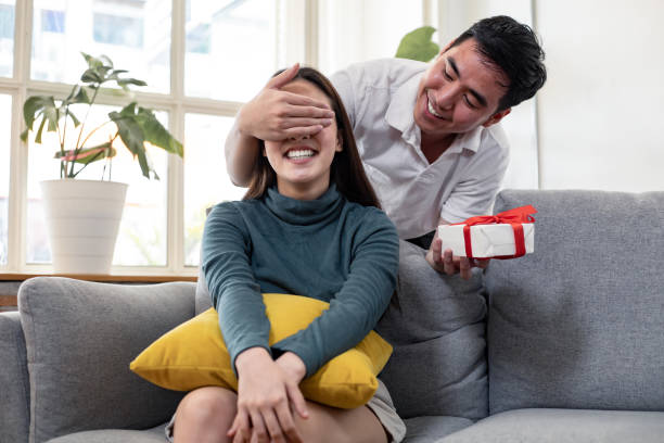 istock Man surprises his girlfriend with gift box. 1199708286