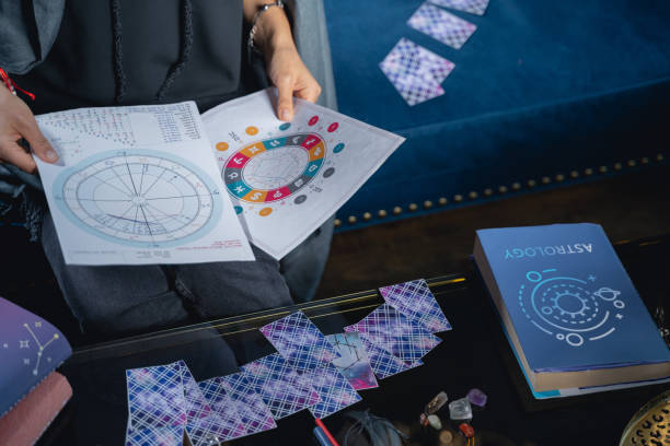istock Astrologer with birth charts sitting at the table 1199710074