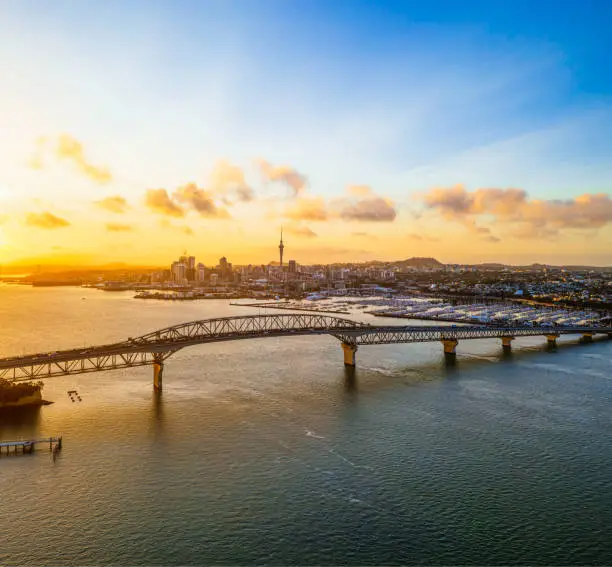 An early morning view of Auckland's city centre, seen across Waitemata Harbour and the Harbour Bridge.
