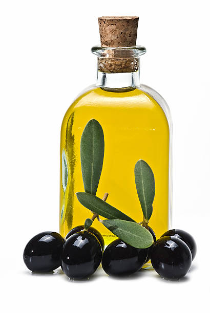 Bottle of olive oil and some black olives. stock photo