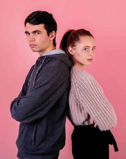 istock unhappy couple standing back to back isolated on pink background 1199716703
