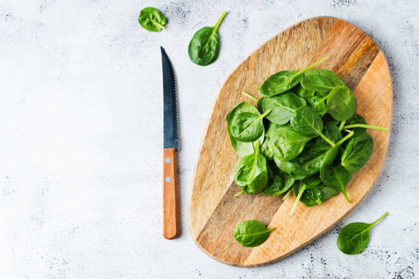 istock Raw fresh spinach leaves on a stone background 1199717122