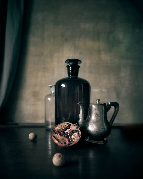 Still life photography in a classic, old painting style A composition with pomegranate fruit a silver kettle and a large brown bottle still life photos stock pictures, royalty-free photos & images