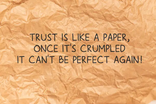 Photo of Trust Is Like A Paper Once Its Crumpled quote over Crumpled Brown Paper Background
