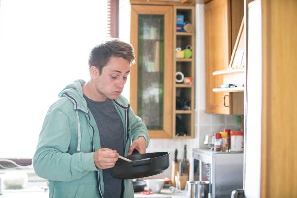 Young Adult Man Tasting Prepared Meal.