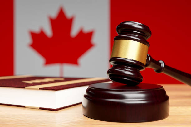 primo piano del martello del giudice su un tavolo di legno sullo sfondo della bandiera canadese, il concetto di legislazione canadese.3d rendering. - canadian flag flag trial justice foto e immagini stock