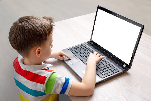 istock Boy use a laptop computer mockup. Isolated screen for app, game or web site design presentation. Concept of working and playing on a computer 1199719048