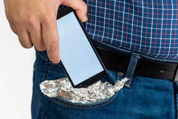 istock Person putting a smartphone in his pocket covered with foil 1199719637