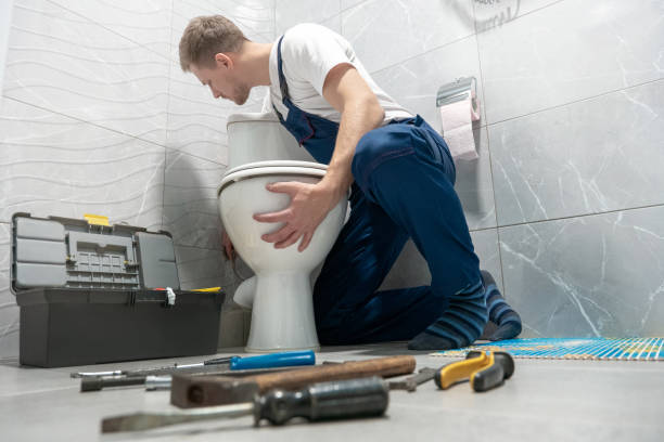 man plumber in uniform installing toilet bowl using instrument kit professional repair service man plumber in uniform installing toilet bowl using instrument kit professional repair service. toilet bowl stock pictures, royalty-free photos & images