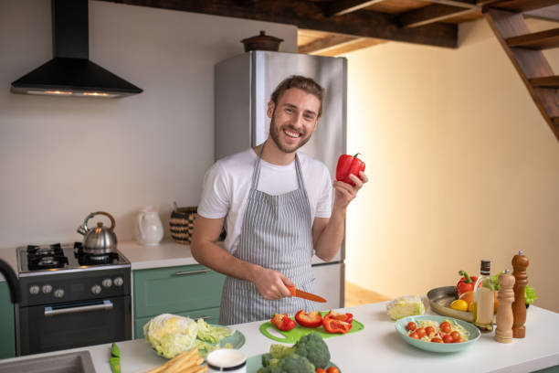 istock Smiling cook making a new dish with pepper 1199720691