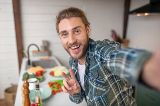 homme de sourire faisant le selfie sur sa cuisine - social networking youtube internet leisure activity photos et images de collection