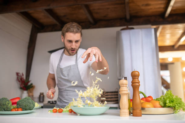 Professional cook putting cabbage into a salad