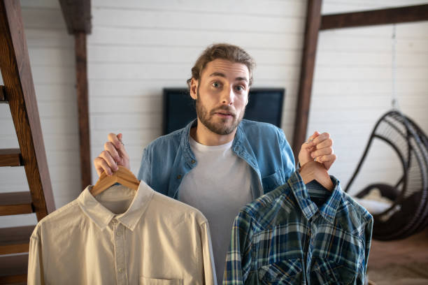 istock Man doubting which shirt to choose for a date 1199720975