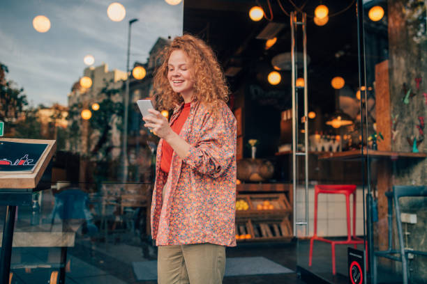 istock Young redhead texting on the phone 1199723533