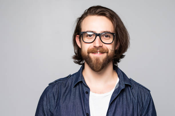 istock Young man with glasses smiling isolated on gray background 1199724079