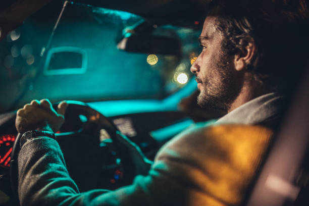 istock Businessman Driving A Car In Night 1199728844