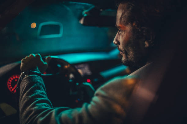 istock Businessman Driving A Car In Night 1199729379