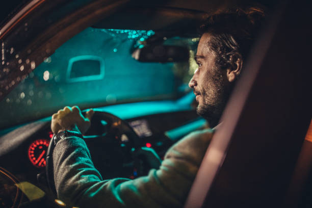 istock Businessman Driving A Car In Night 1199729496
