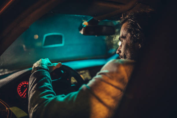 istock Businessman Driving A Car In Night 1199729782