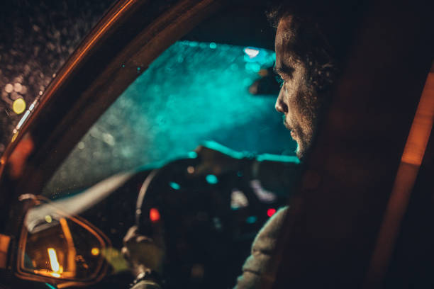 istock Businessman Driving A Car In Night 1199729824