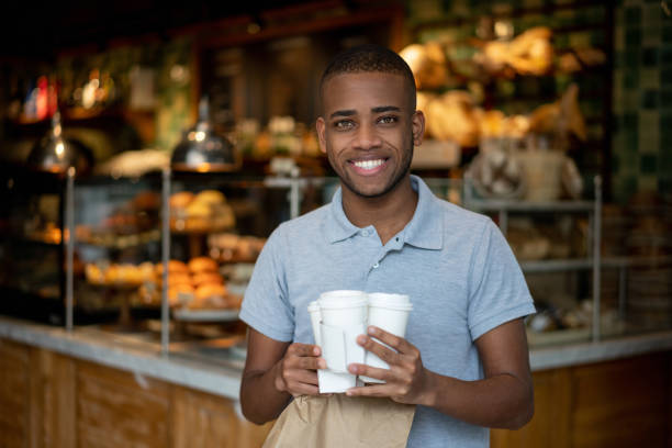 istock Happy man buying several cups of coffees at a cafe 1199731082
