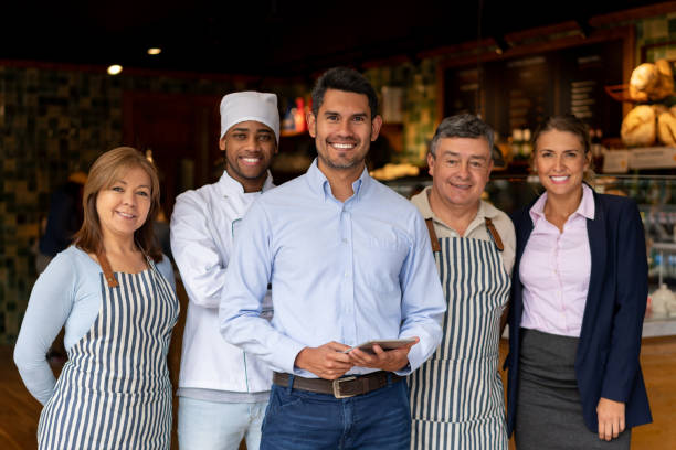 istock Happy business owner at a restaurant with his staff 1199731096