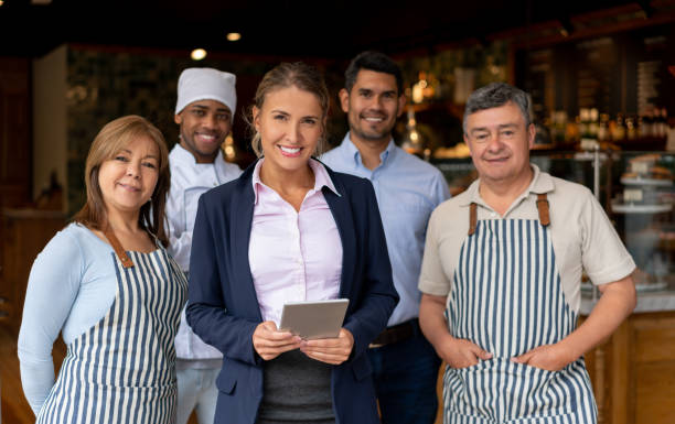 istock Happy business owner at a restaurant with her staff 1199731097