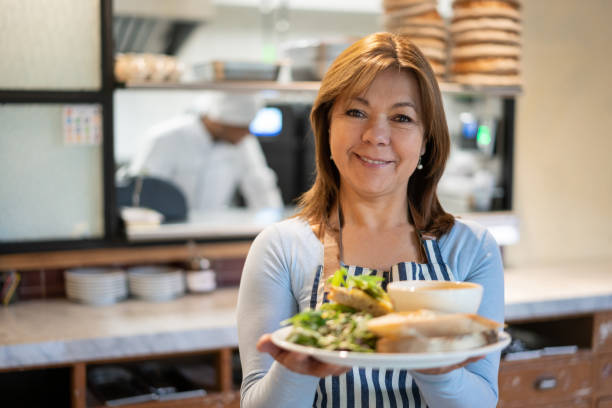 istock Happy waitress serving food at a restaurant 1199731119