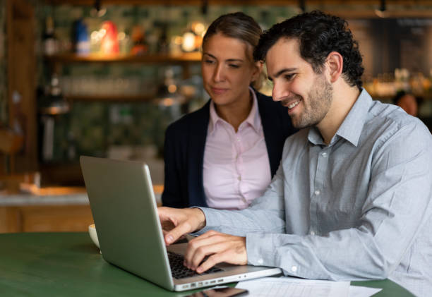 istock Entrepreneurs working online at a cafe on a laptop computer 1199731473