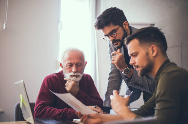 istock Three businessmen looking worried while examining the reports printed on the paper in an office. They don't quite like what they see and are thinking. 1199733687