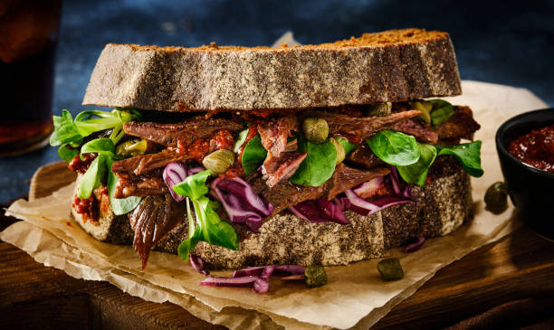 istock Juicy grilled beef sandwich with greens, capers and cabbage and sauce. 1199735292