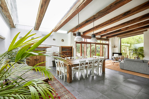 Spacious living room with dining table in a bright refurbish Mediterranean farmhouse.