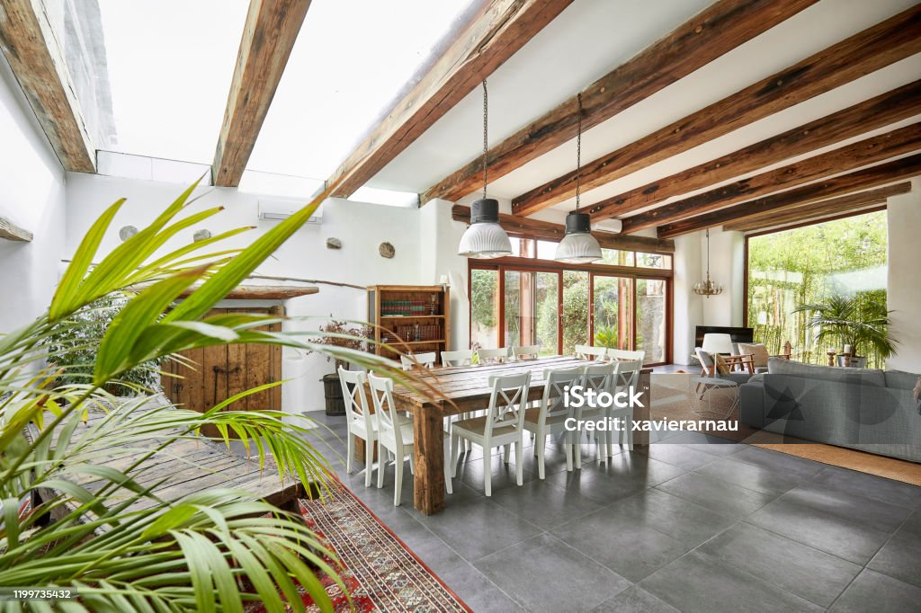 Spacious dining area in a bright refurbish Mediterranean farmhouse Spacious living room with dining table in a bright refurbish Mediterranean farmhouse. Home Interior Stock Photo