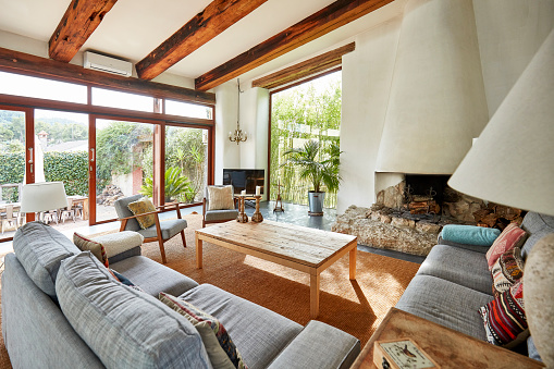View of a spacious living room with fireplace in a bright Mediterranean farmhouse.