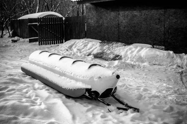 Photo of Riding an inflatable banana in the snow on a clear spring day.