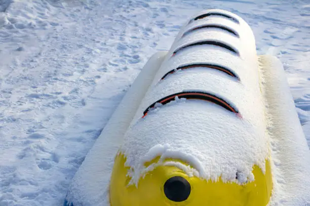 Photo of Riding an inflatable banana in the snow on a clear spring day.