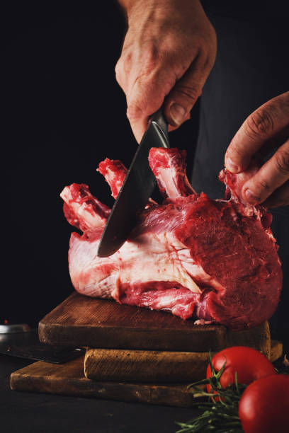 istock Male butcher cuts raw beef meat. 1199736372