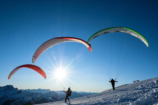 Schoppernau Diedamkopf, Vorarlberg, Austria - January 06, 2020: Paraglider are ready to start on a winter flight with blue sky