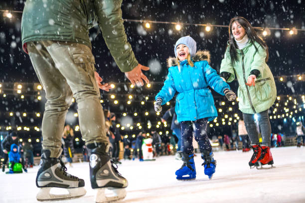 patinoire. famille heureuse sur la patinoire. maman et papa apprennent à la fille à patiner. - ice winter white women photos et images de collection