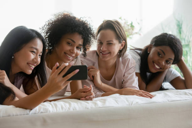 istock Happy diverse girls making selfies on cell at party 1199737484