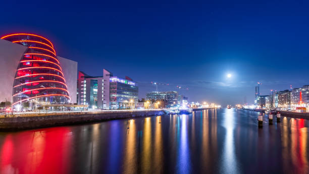 Blue hour at Dublin docks. Beautifully illuminated embankment and harbour. Blue hour at Dublin docks. Beautifully illuminated embankment and harbour. Blurred water on Liffey river estuary. Long exposure photography, Ireland dublin republic of ireland stock pictures, royalty-free photos & images