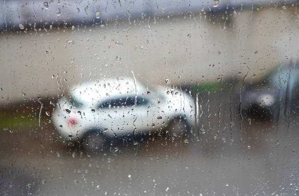 istock Rainy weather. Rain water drops on a window glass. 1199740697