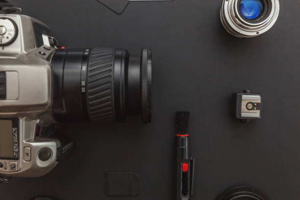 istock Photographer workplace with dslr camera system, camera cleaning kit, lens and camera accessory on dark black table background. Hobby travel photography concept Flat lay top view copy space 1199740890