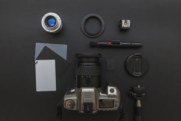 Photographer workplace with dslr camera system, camera cleaning kit, lens and camera accessory on dark black table background. Hobby travel photography concept. Flat lay top view copy space lugar de trabajo de fotógrafo con sistema de cámara dslr, kit de limpieza de cámara, lente y accesorio de cámara sobre fondo de mesa negro oscuro. concepto de fotografía de viaje hobby. espacio de copia de vista superior de la vista superior plana