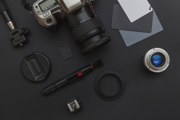 istock Photographer workplace with dslr camera system, camera cleaning kit, lens and camera accessory on dark black table background. Hobby travel photography concept. Flat lay top view copy space 1199740903