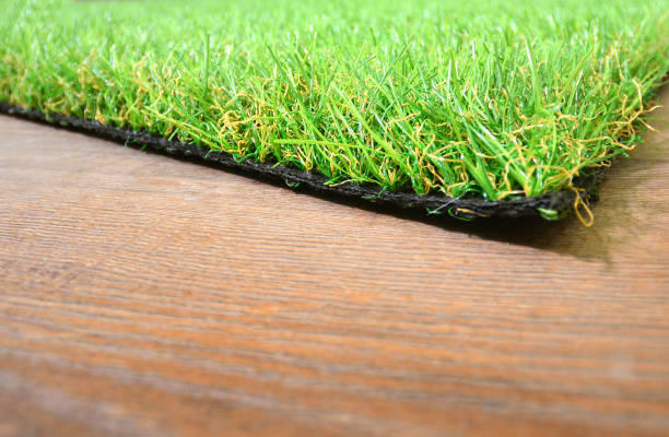 istock Artificial grass lie on the wooden background 1199741889
