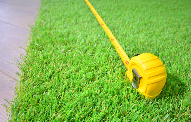 Artificial turf and measure tape lie on the laminate floor Artificial turf and measure tape lie on the laminate floor yard measurement stock pictures, royalty-free photos & images